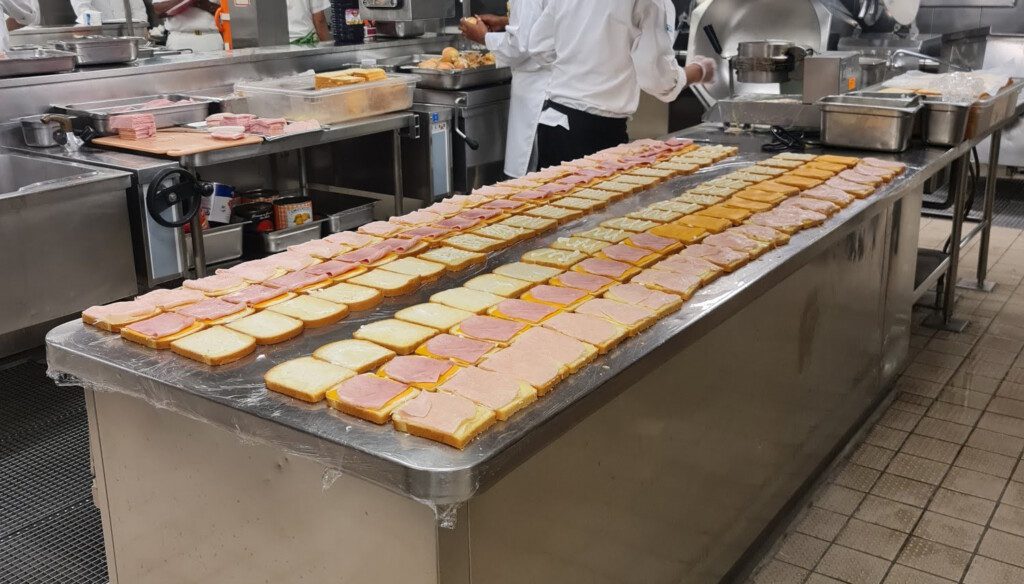 a large counter with rows of sandwiches