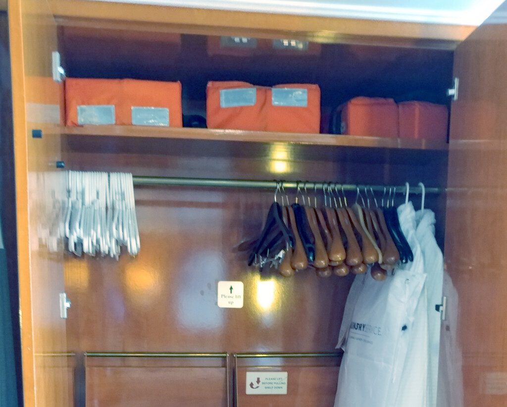 a closet with swingers and clothes on the shelf