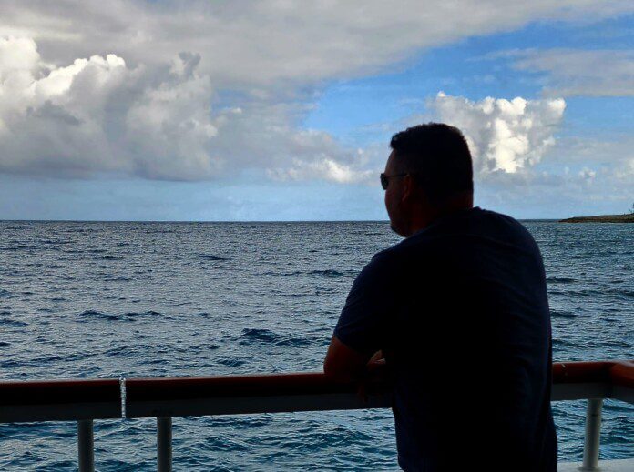 a man standing on a boat looking out over the ocean
