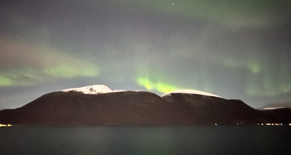 a green lights in the sky above a mountain