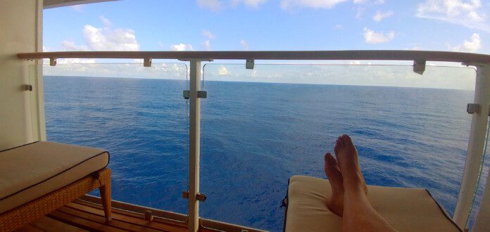 a person's feet on a deck overlooking the ocean