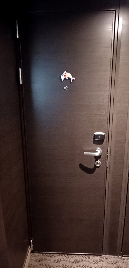 a door with a keyhole and a toy fish on it