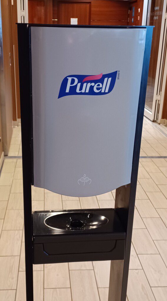a hand sanitizer dispenser on a tile floor