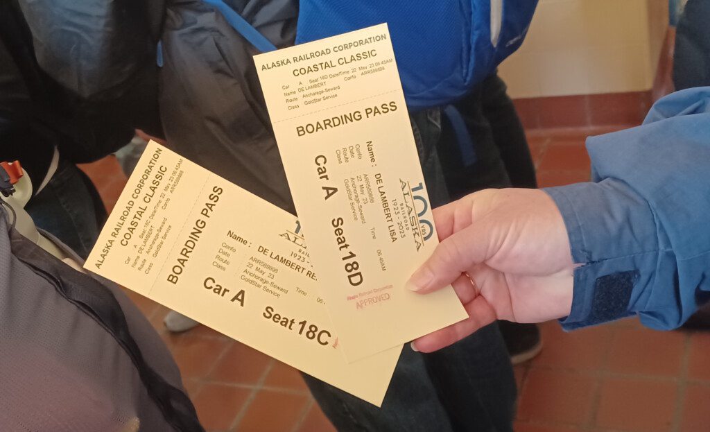 a pair of hand holding tickets