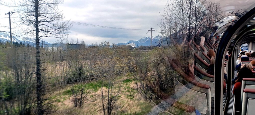 a view of a field and mountains from a train window