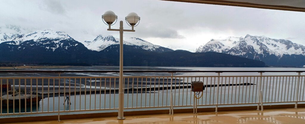 a light pole with a railing overlooking a body of water and mountains
