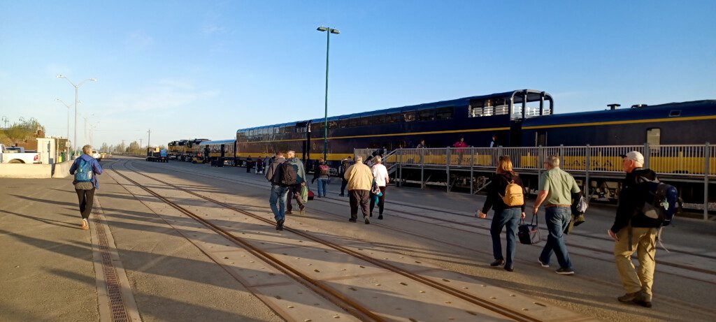 a group of people walking on tracks next to a train