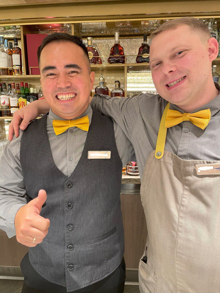 two men in vests and yellow bow ties