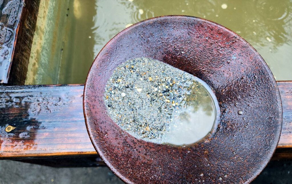 a metal bowl with a small rock in it