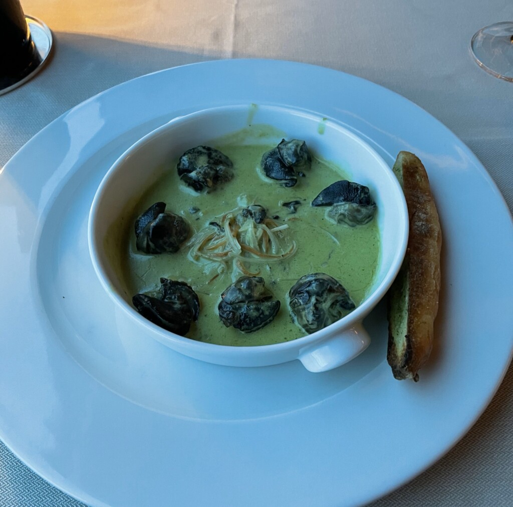 a bowl of soup with a piece of bread on a plate