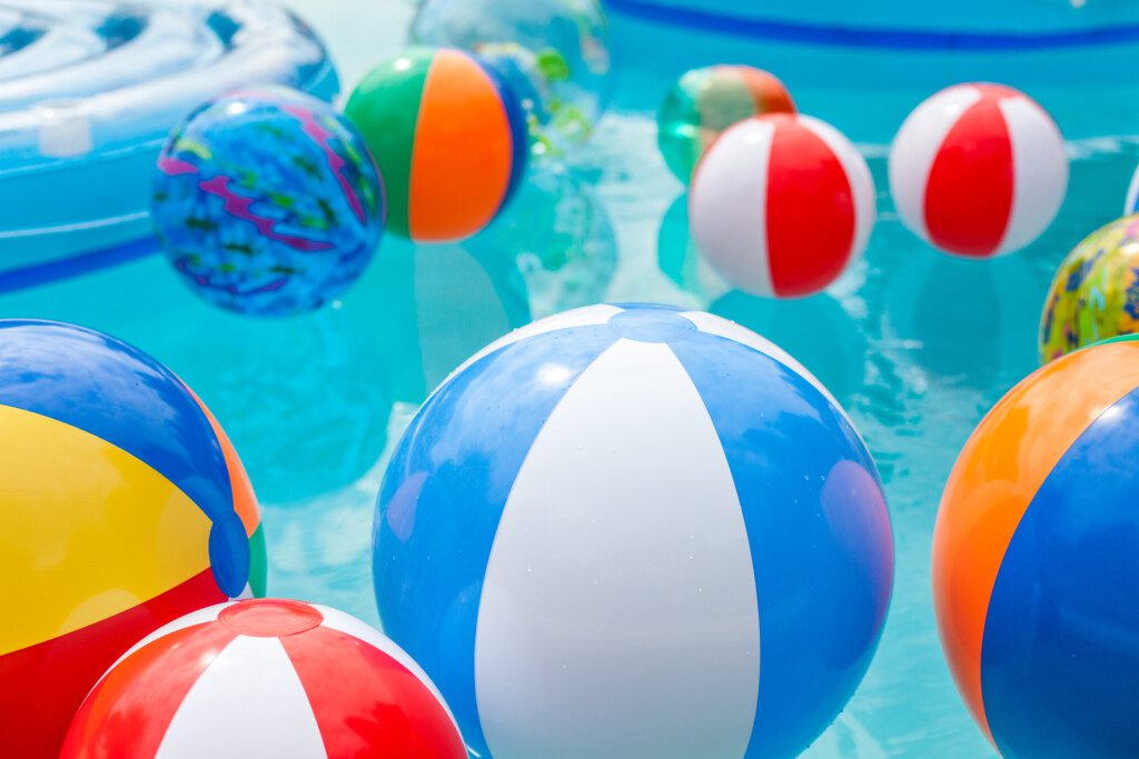 Multi-colored beach balls in a pool