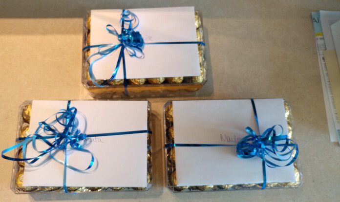 a group of wrapped chocolates with blue ribbons