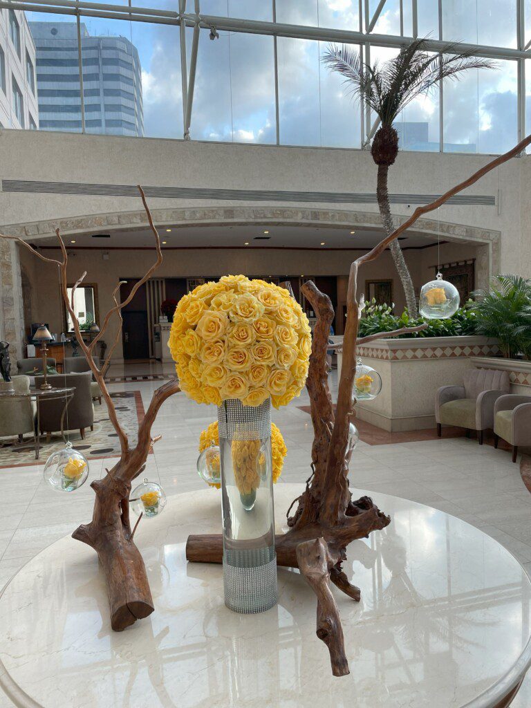 a large bouquet of yellow roses in a glass vase