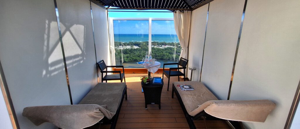 a room with a table and chairs and a view of the ocean