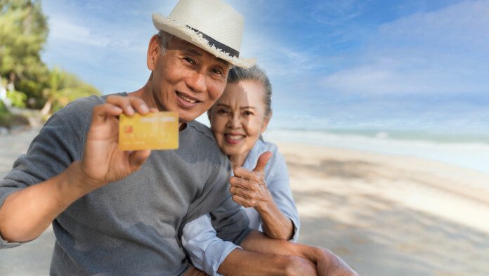 Adorable couple on vacation showing off their credit card