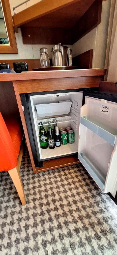 a mini fridge with beer bottles inside