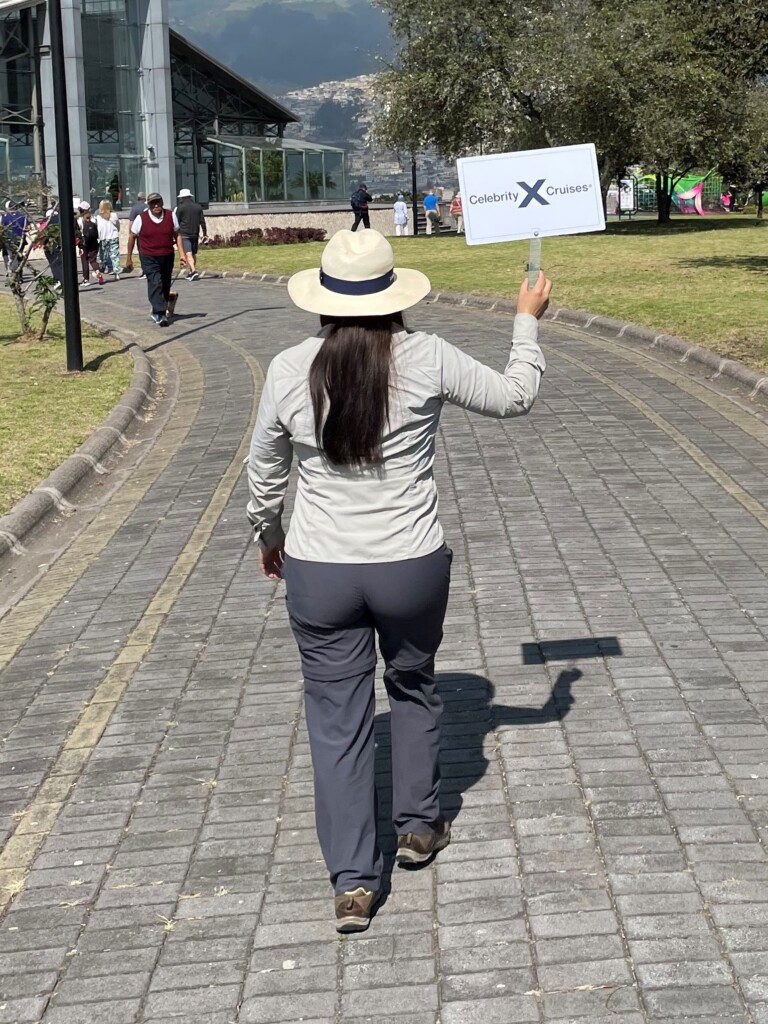 a woman walking on a sidewalk holding a sign
