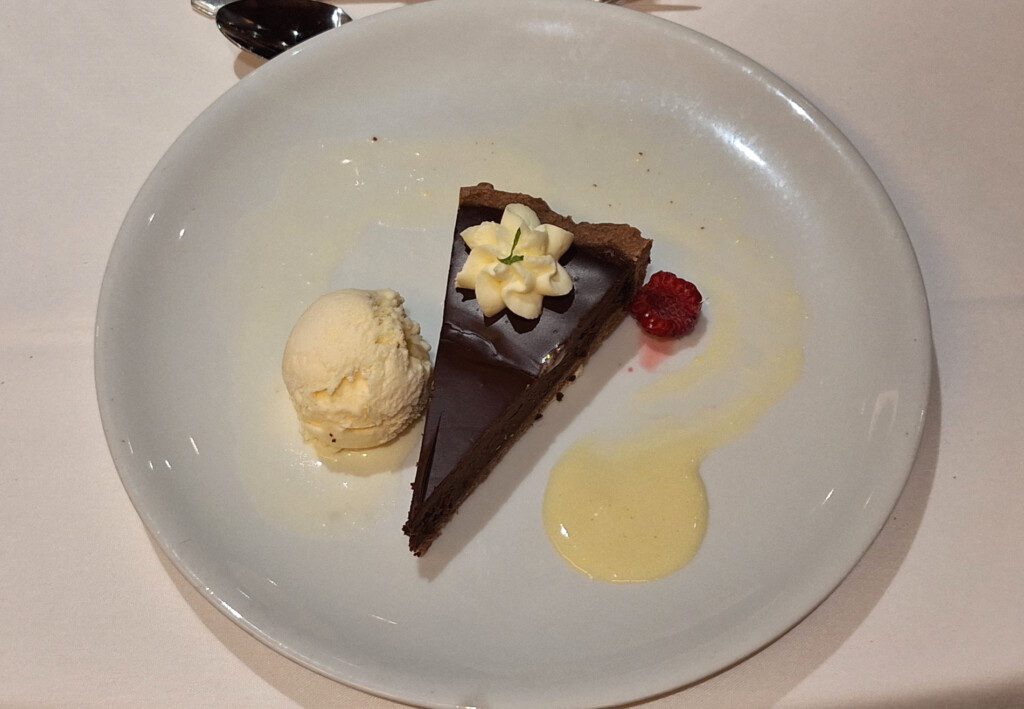 a slice of chocolate cake with ice cream on a white plate