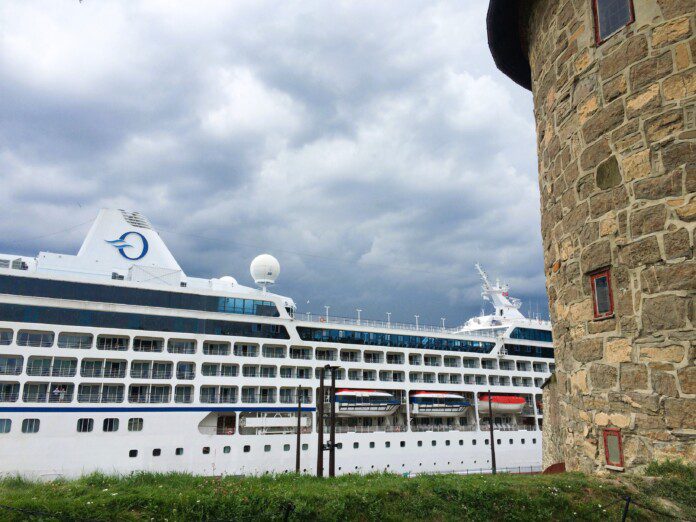 a large cruise ship in front of a stone building