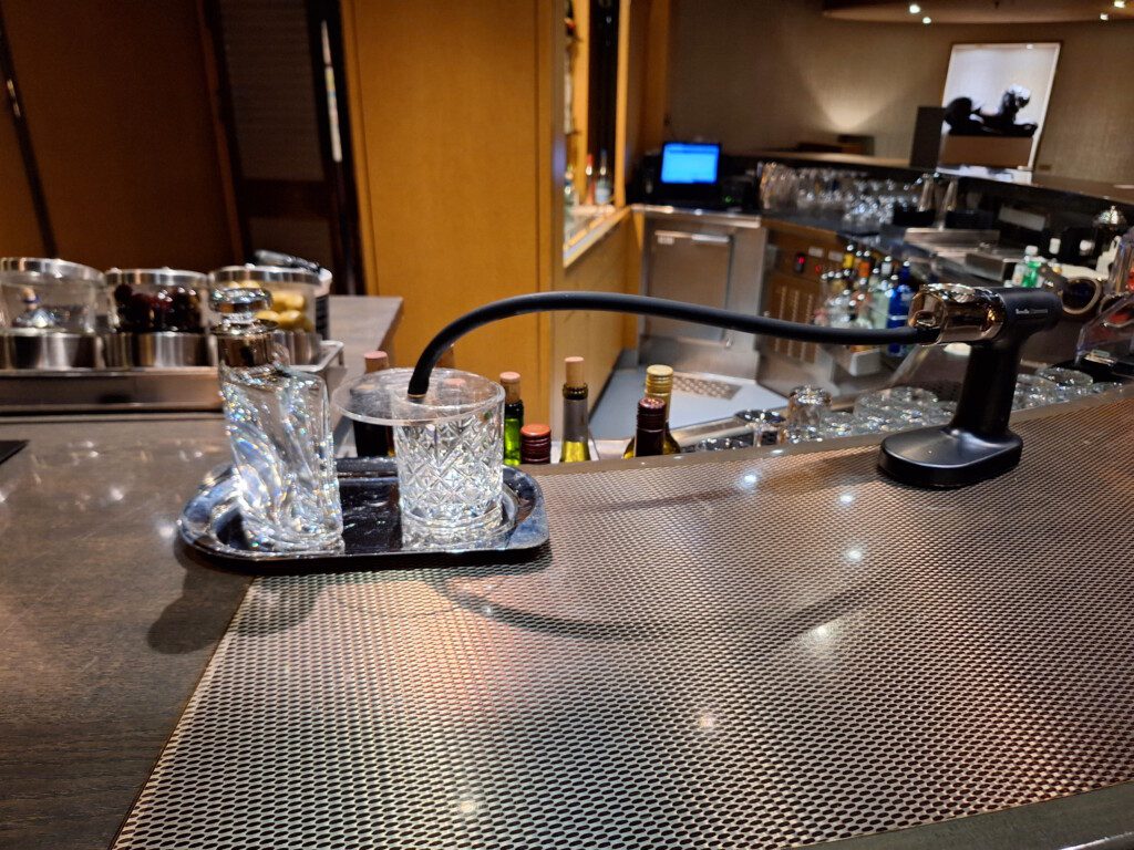 a bar with glasses and a black pipe