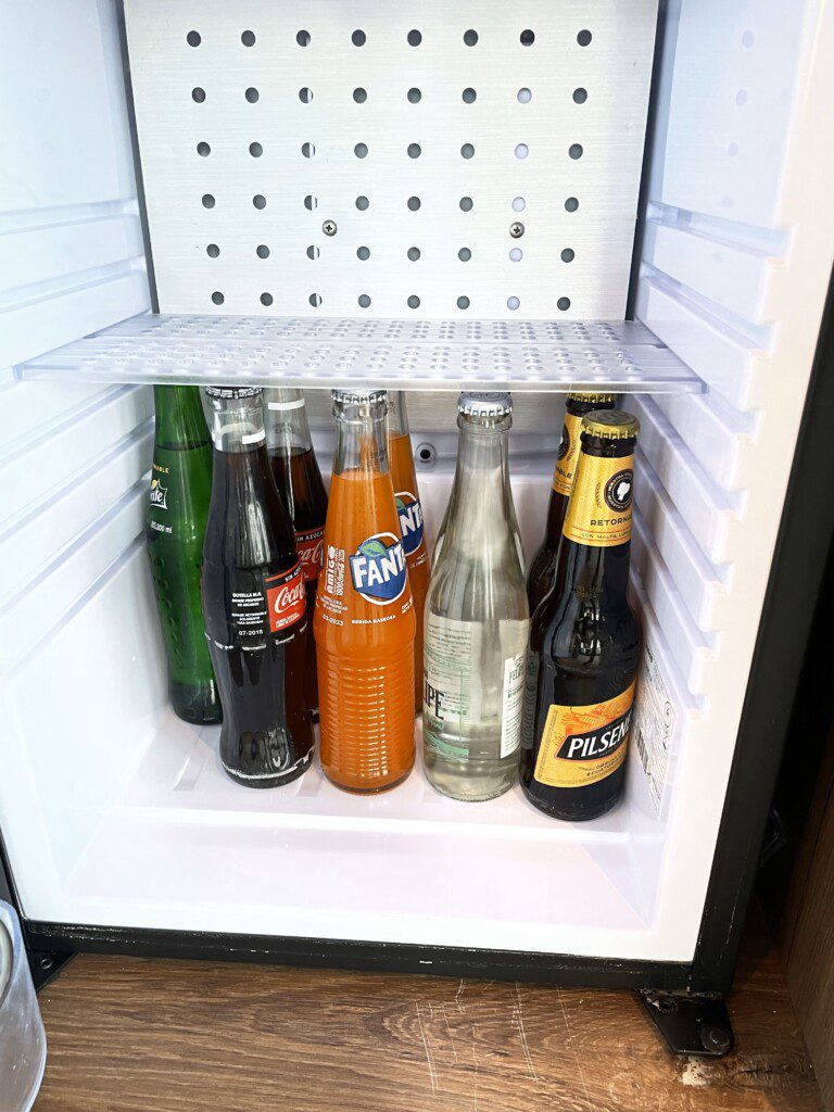 a refrigerator with bottles of soda