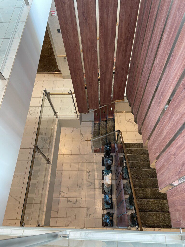 a staircase with glass railings and wood slats