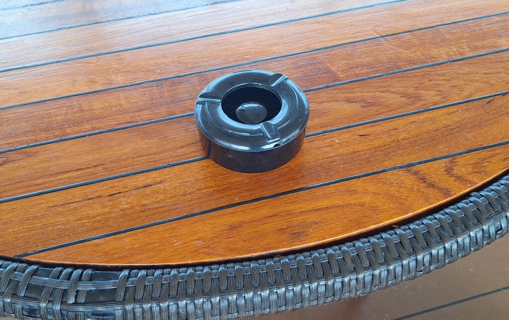 a black ashtray on a wooden table