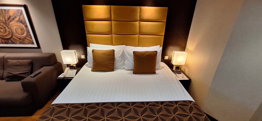 a bed with pillows and a brown headboard