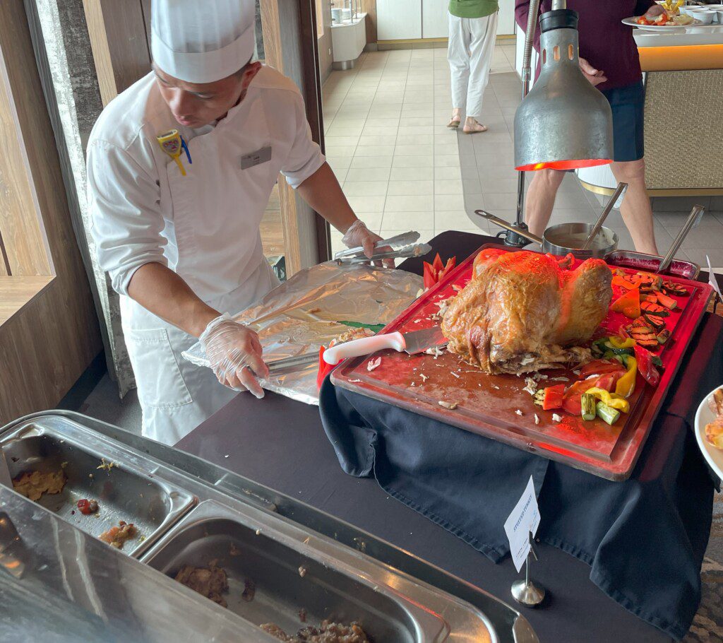 a chef cutting a turkey on a tray