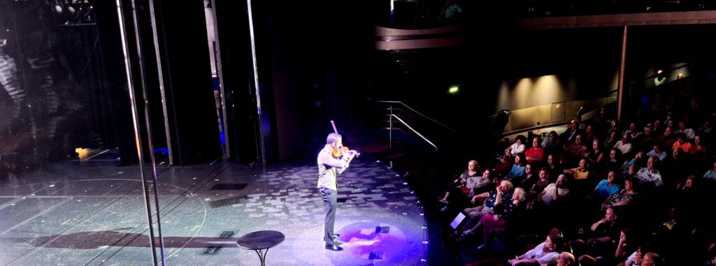 a man playing a violin on a stage