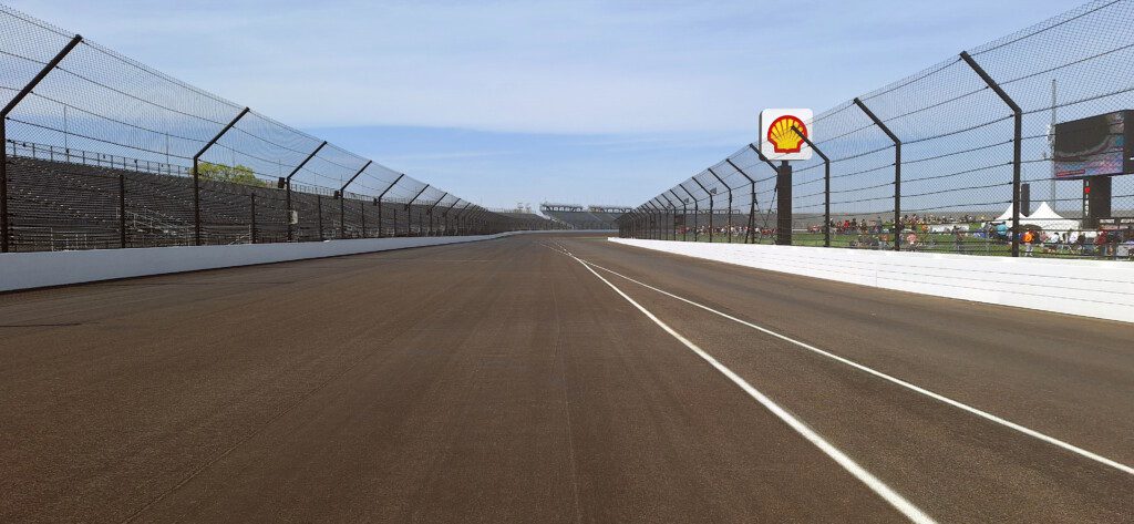 a race track with a fence and a sign