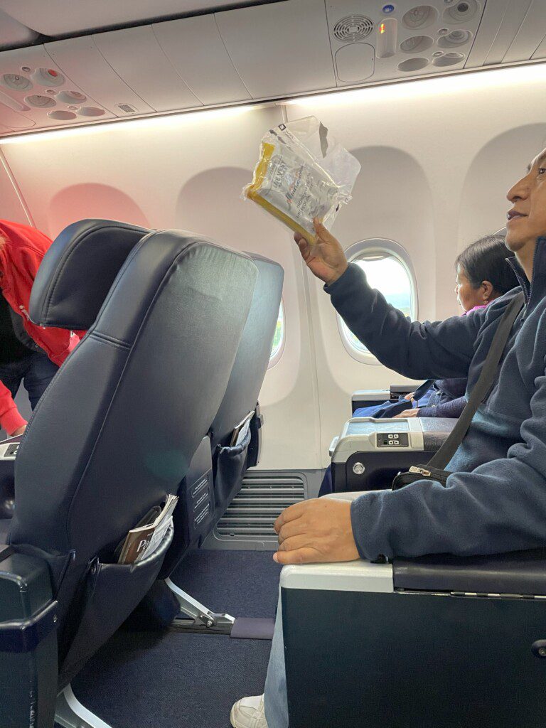 a man holding a package in an airplane