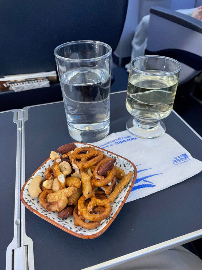 a plate of snacks and two glasses of water on a tray