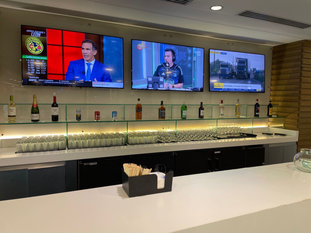 a bar with several tvs and bottles