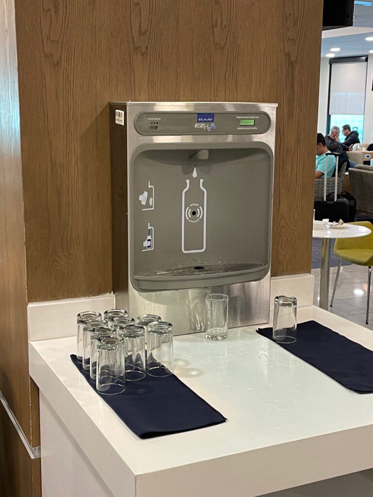 a water dispenser with glasses on a table