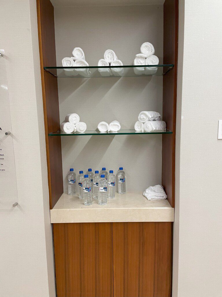 a shelf with towels and water bottles