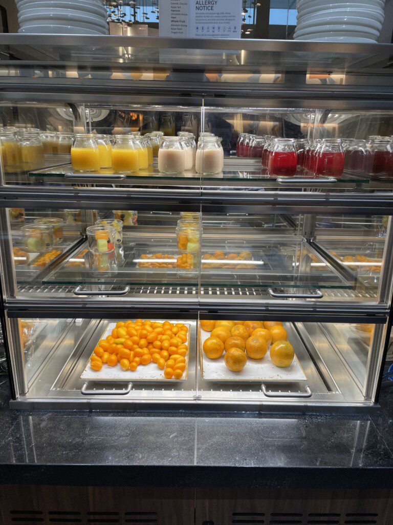 a glass display case with different fruits and drinks