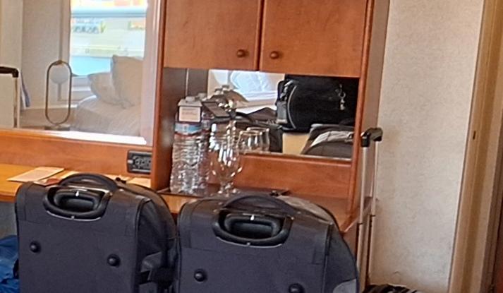 a mirror with a glass and a bottle of water on it